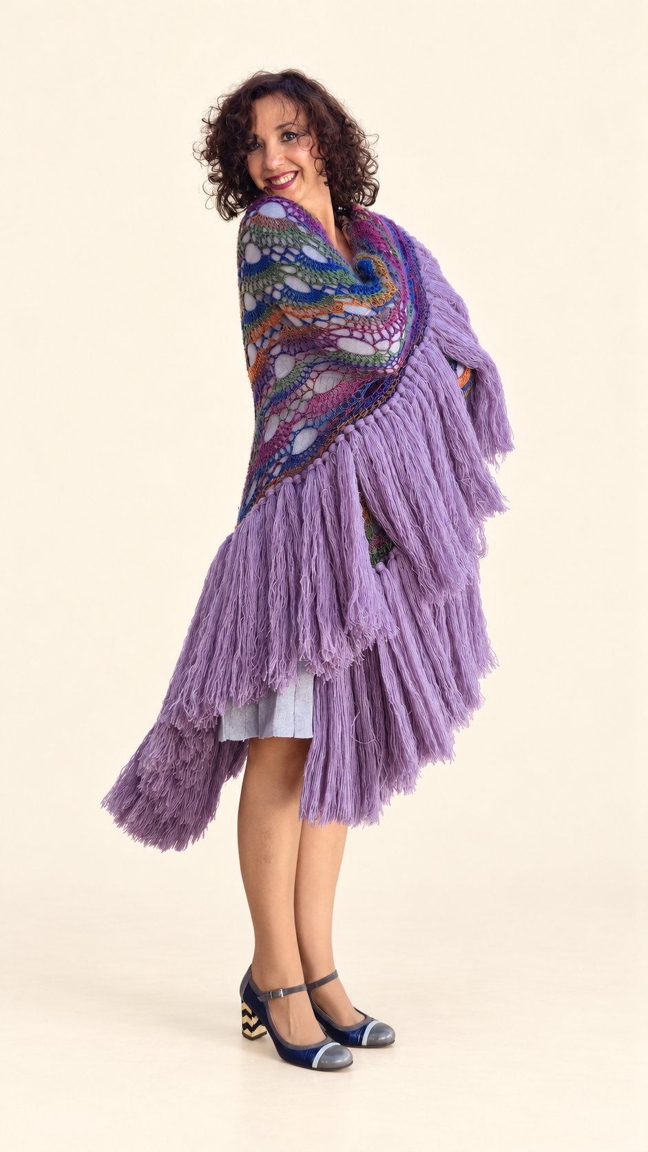 Chal Claudia de lana multicolor con flecos lilas, vista frontal de la caída, fondo crema