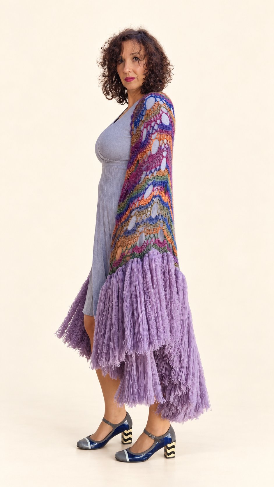 Chal Claudia de lana multicolor con flecos lilas, vista lateral abierto, fondo crema