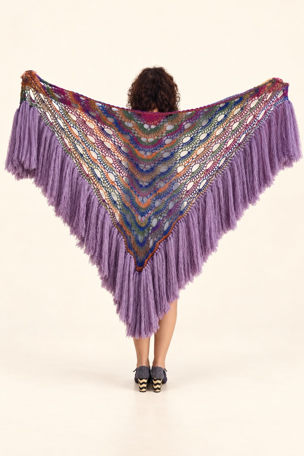 Chal Claudia de lana multicolor con flecos lilas, extendido de espaldas, fondo crema