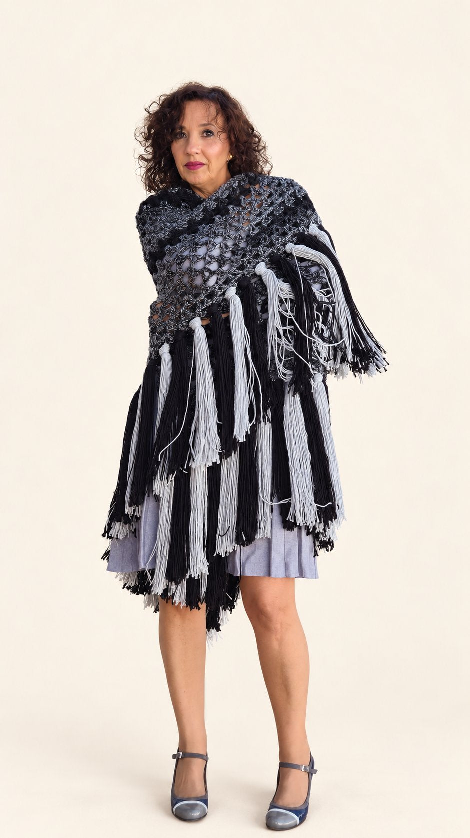 Chal Marian de lana gris y negra con flecos grises y negros, chal envuelto, vista frontal, fondo crema