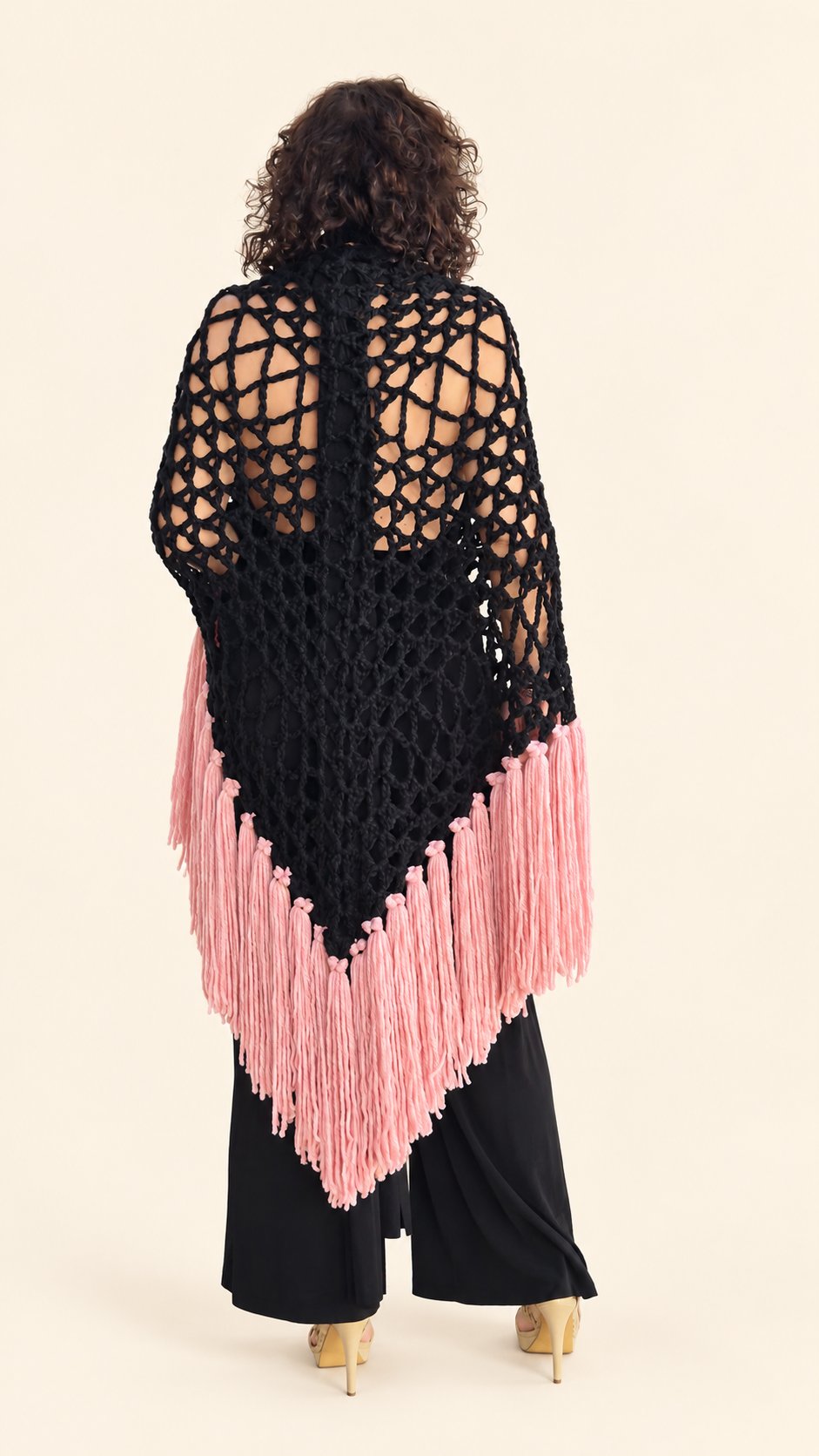 Chal Piluka negro con flecos rosa chicle, espalda, fondo crema
