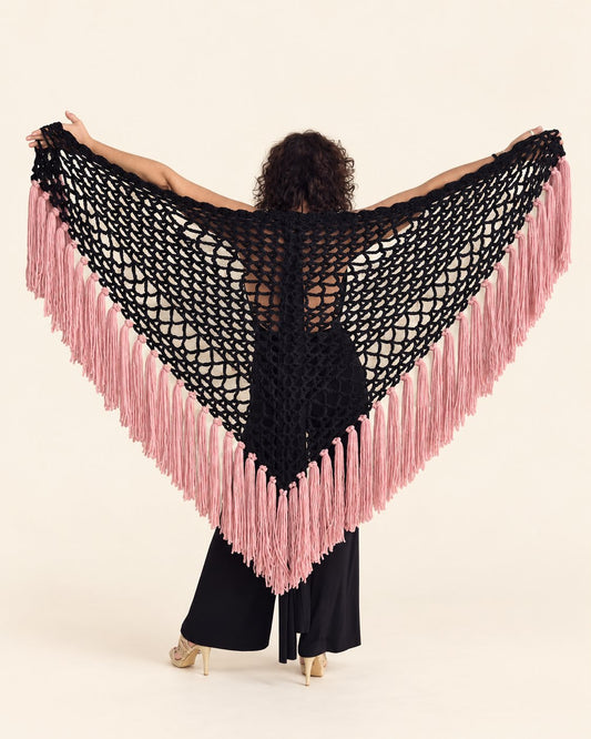 Chal Piluka negro con flecos rosa chicle, espalda con el chal extendido, fondo crema