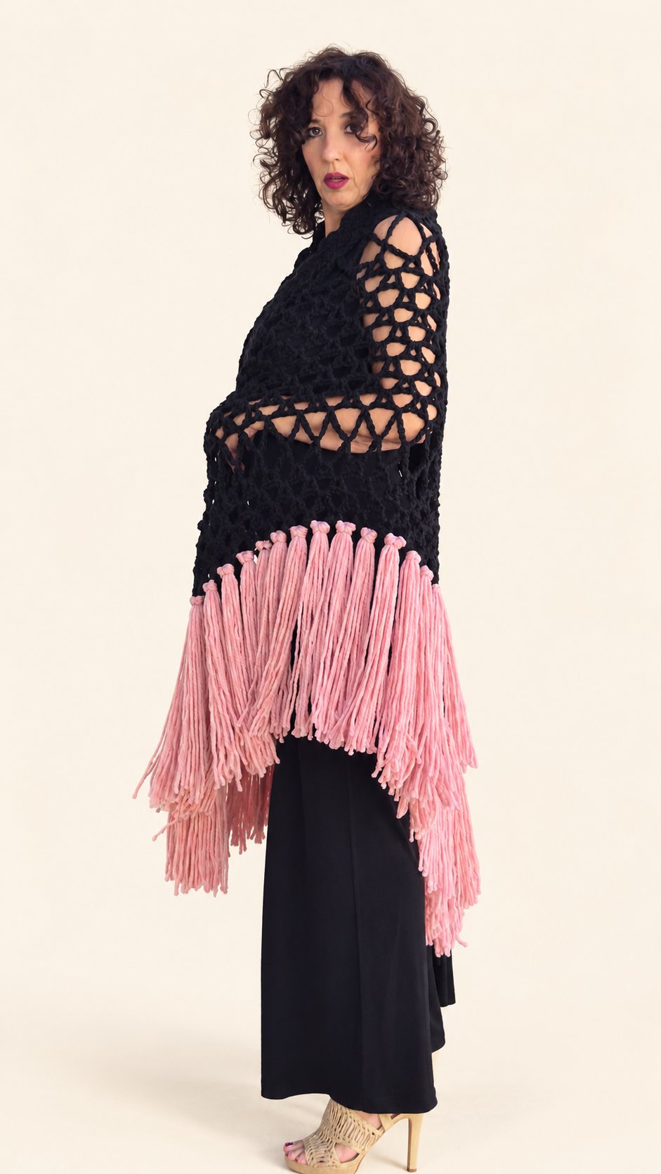 Chal Piluka negro con flecos rosa chicle, lateral con el chal cruzado, fondo crema